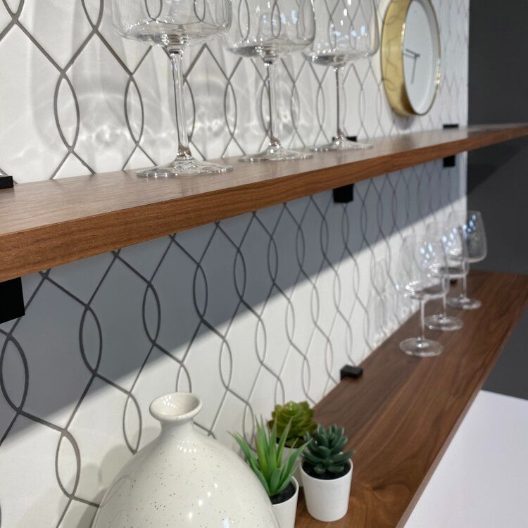 Floating wooden shelves with wine glasses and succulents. Looping tile backsplash.